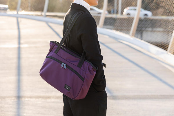 A perosn carrying a Nomad Tote over their shoulder.